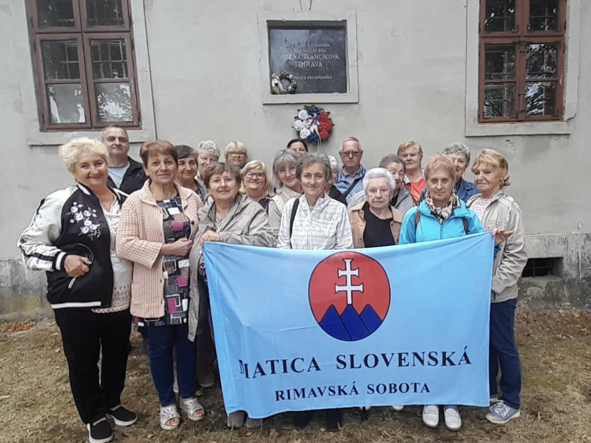 Skupina matičiarov s matičnou zástavou pred rodným domom Boženy Slančíkovej Timravy